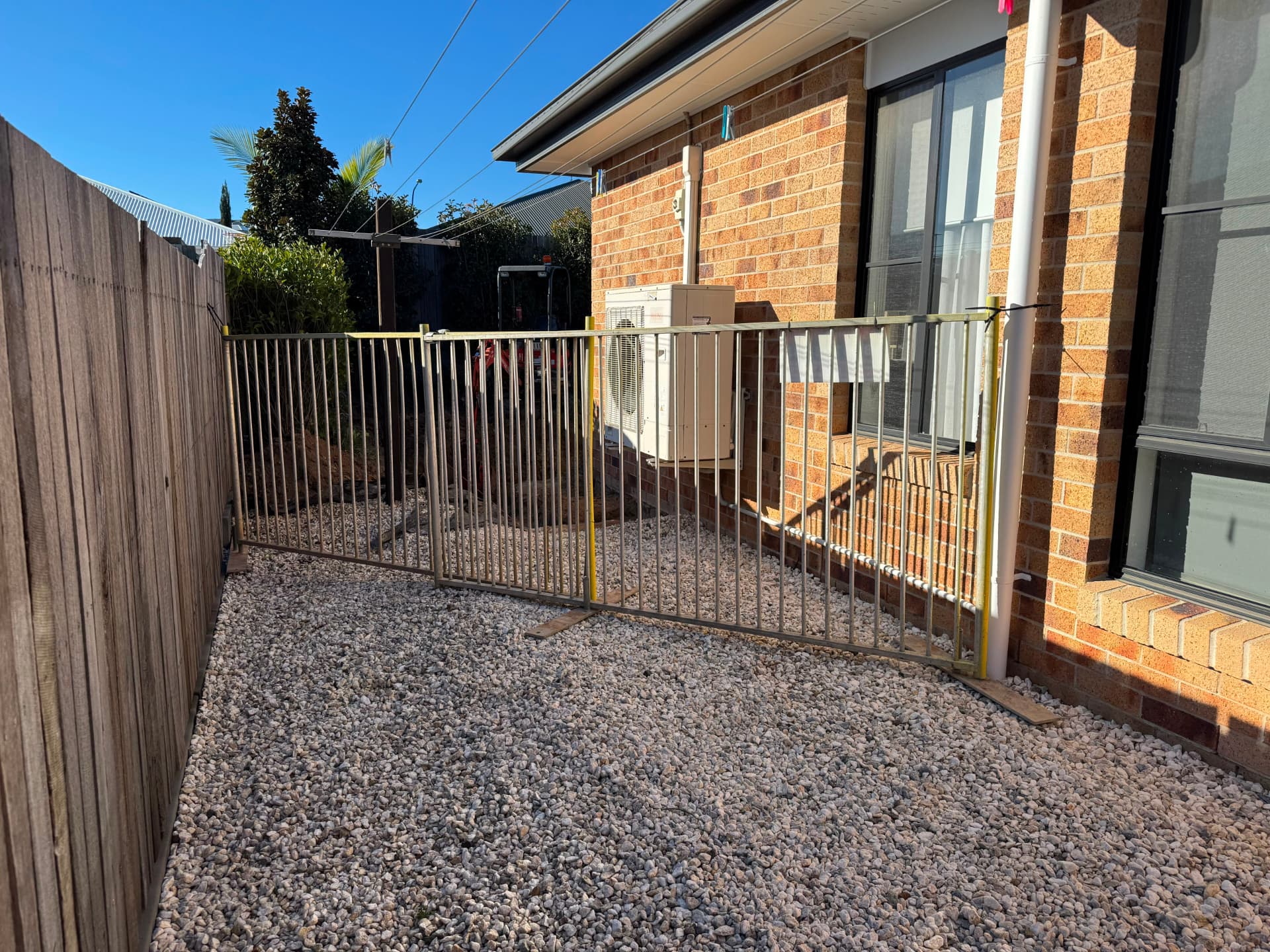 Temporary pool fencing along a side yard on a residential build