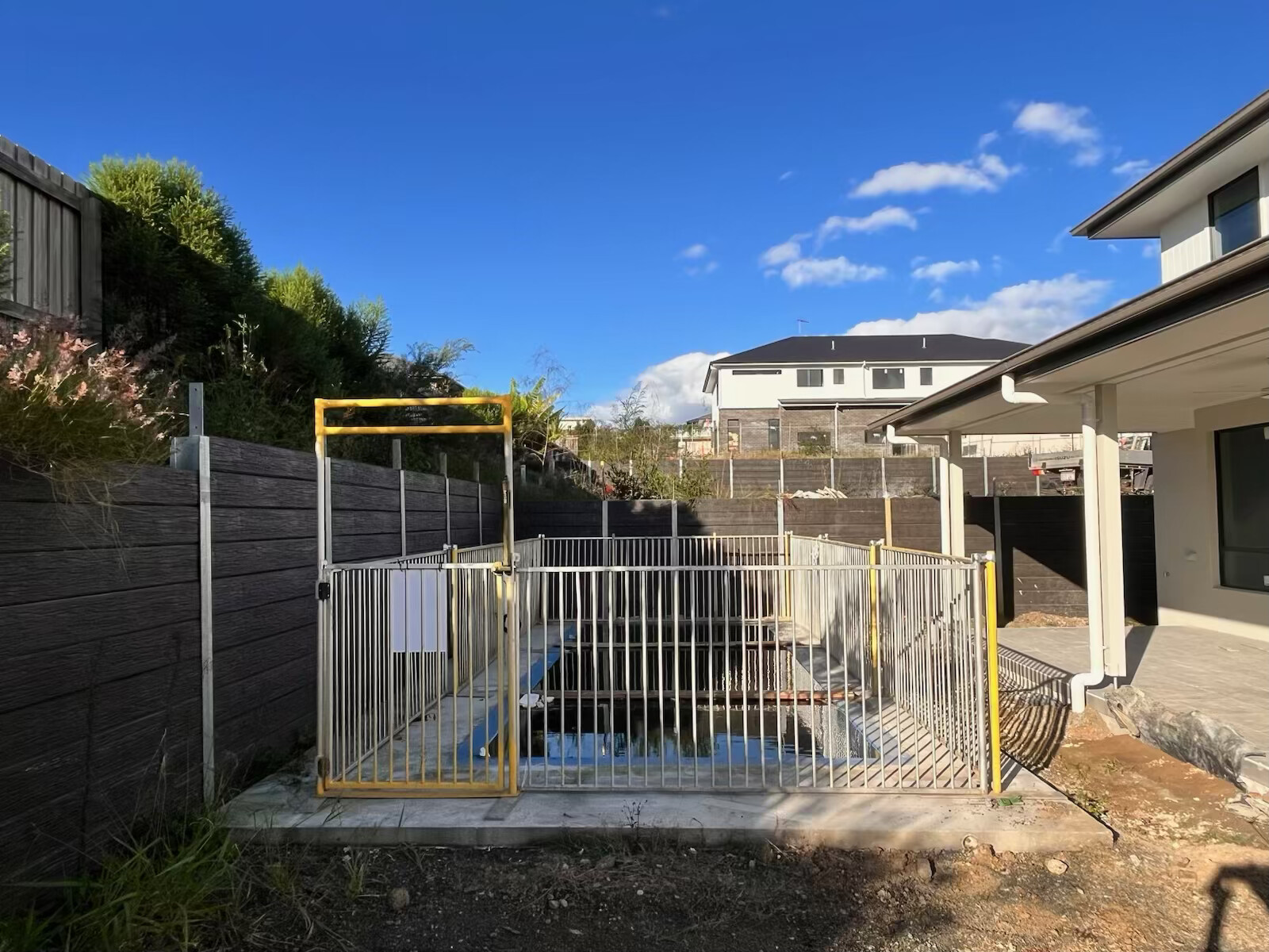 Temporary pool fencing installed beside a landscaped residential boundary