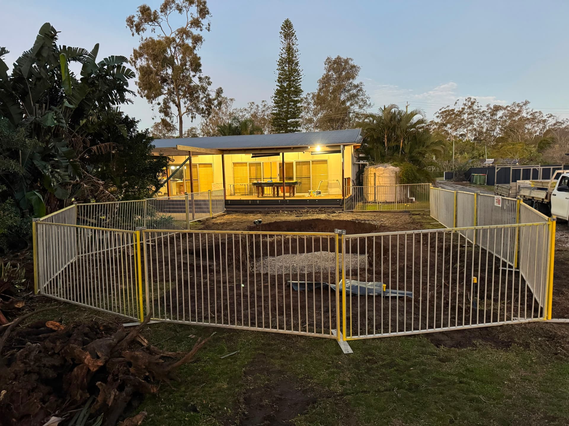 Temporary pool fencing enclosing a pool dig at dusk