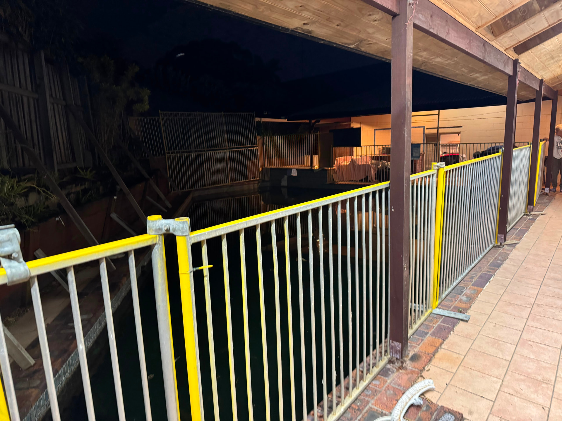 Temporary pool fencing on a poolside walkway