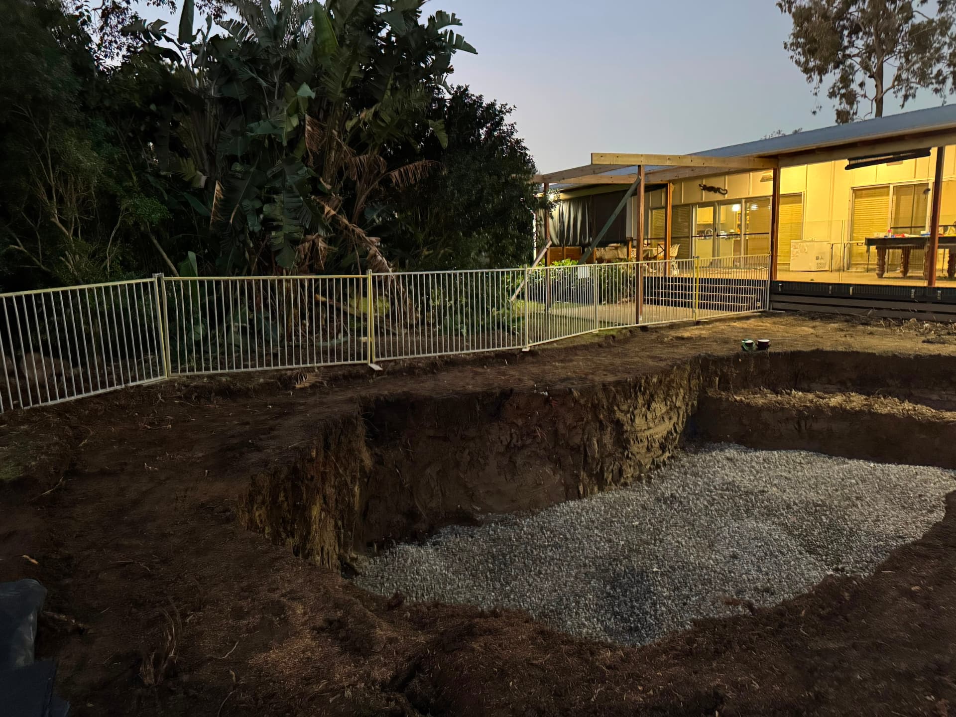 Fenced pool excavation ready for the shell