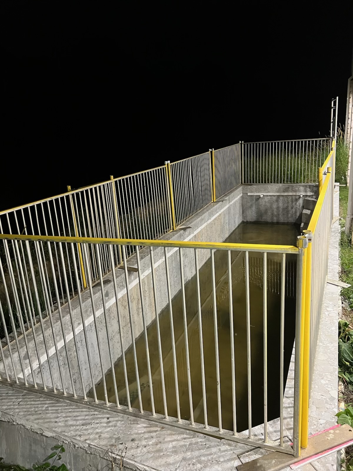 Temporary yellow pool fencing installed around a pool void